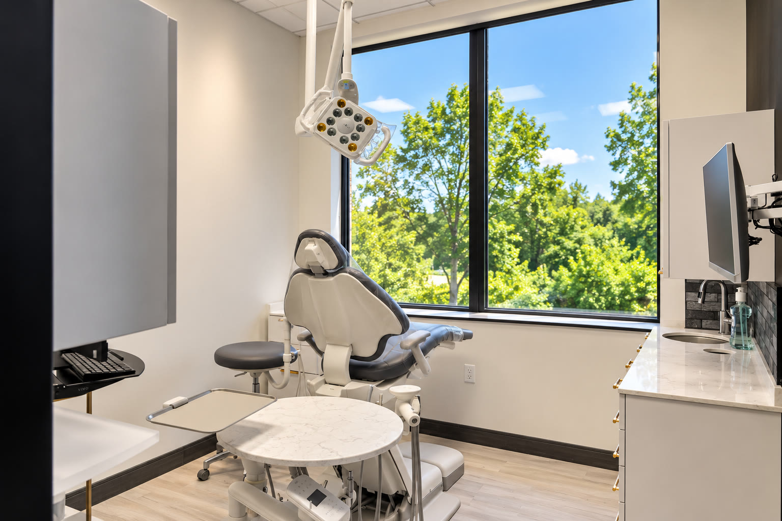 Dental treatment room with a wall of windows onto the trees