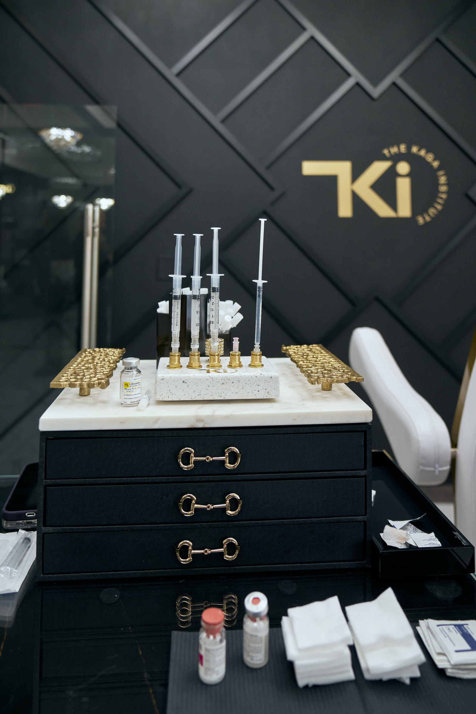 Black marble cabinet with brass hardware and the TKI logo