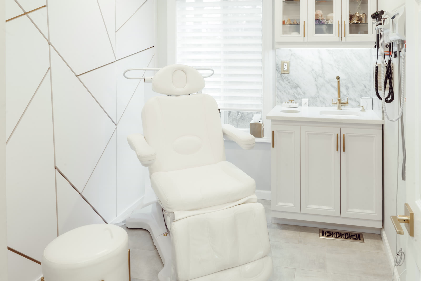 White treatment suite with marble walls and brass details