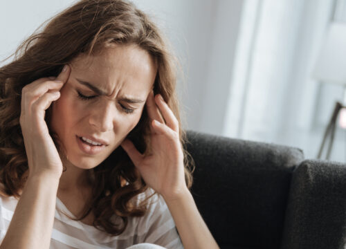 Photo of a woman at home with a migraine