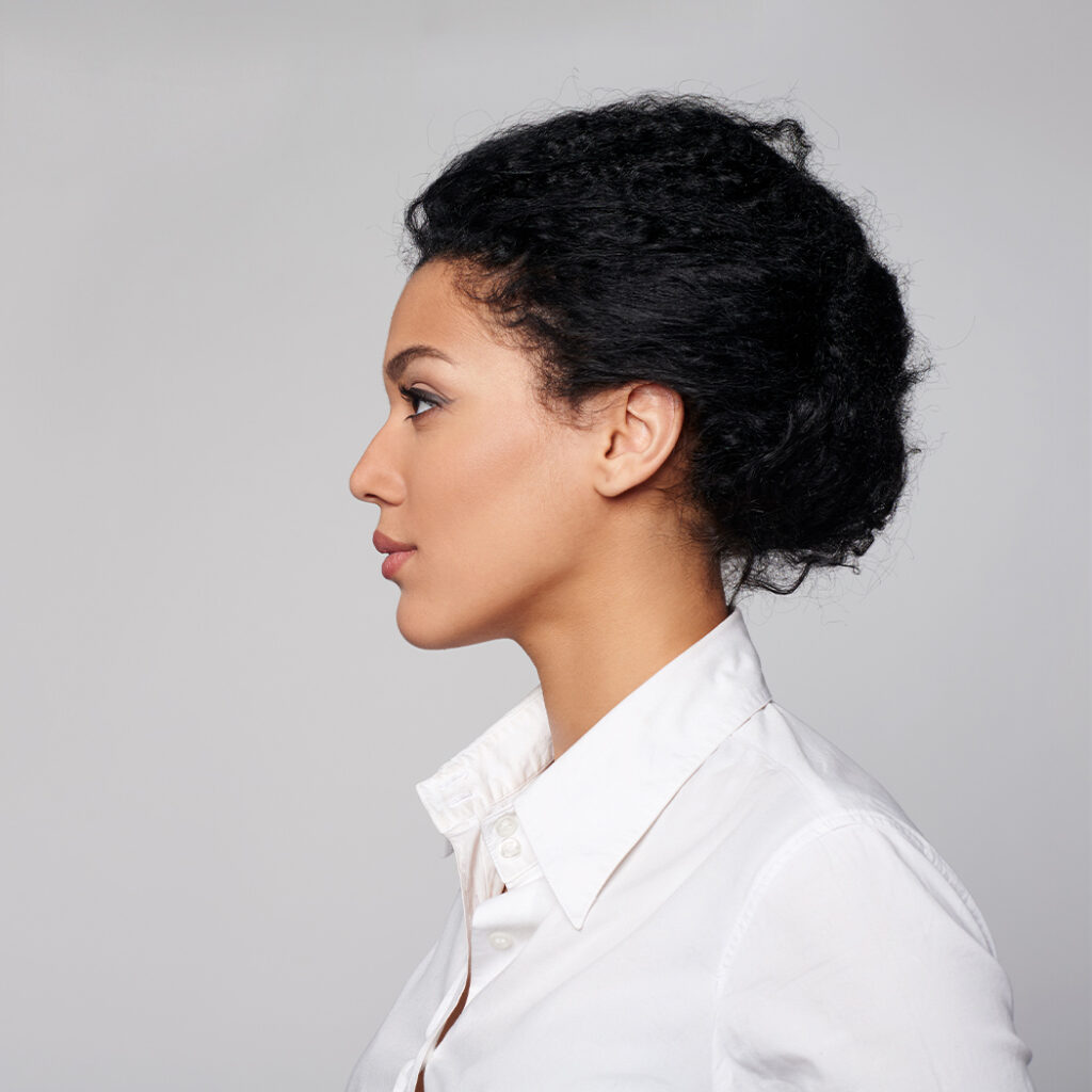 Side view photo of a woman wearing a white collared shirt