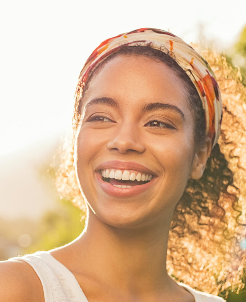 Photo of a happy, smiling woman with the sun shining on her hair
