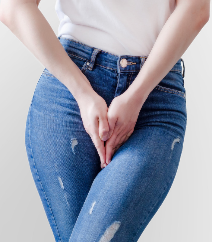 Photo of a woman placing her hands over the front of her jeans