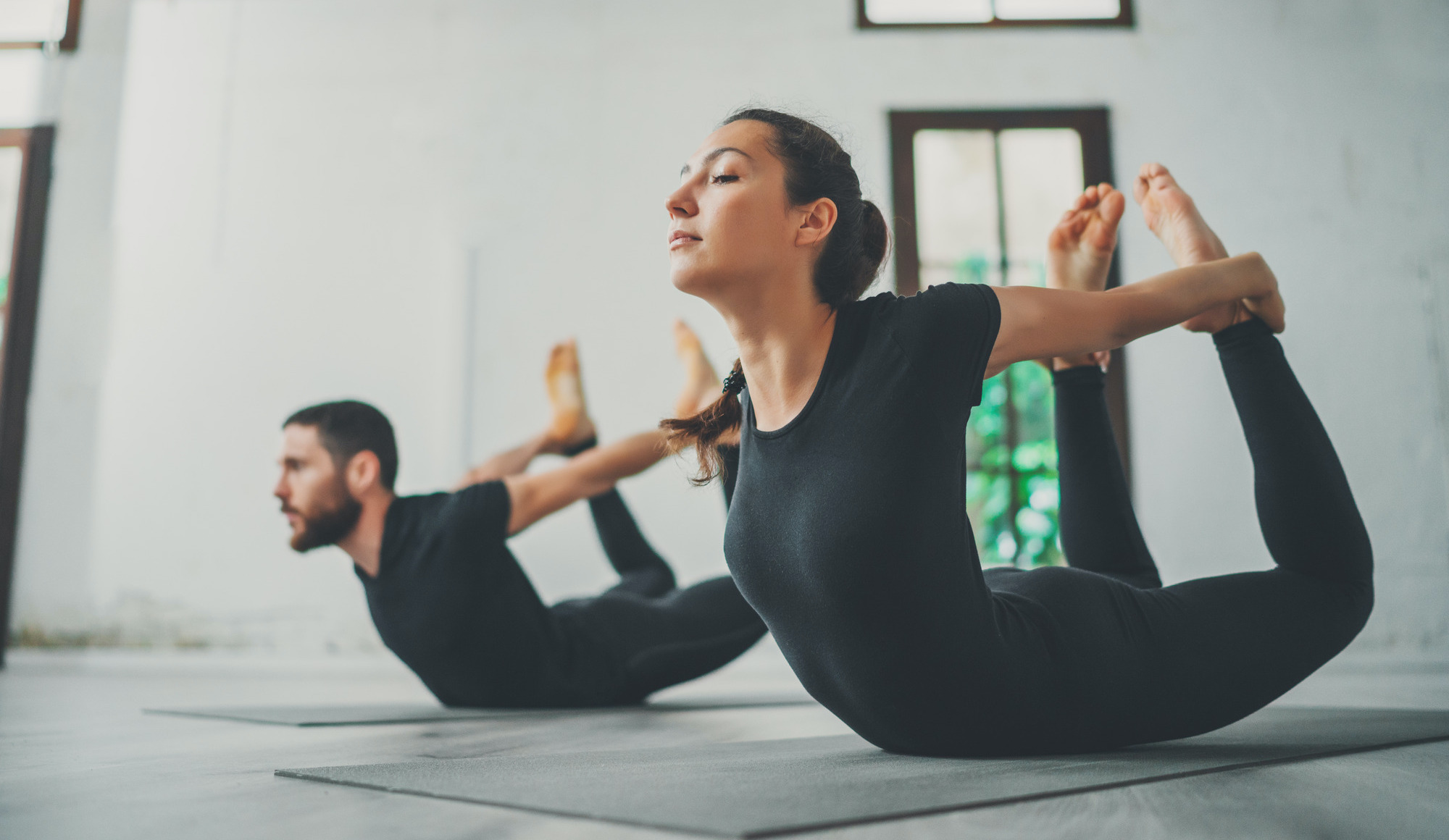 Photo of a woman and man doing yoga