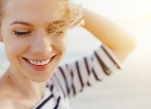 Photo of a blonde woman outside in the sunlight with great skin