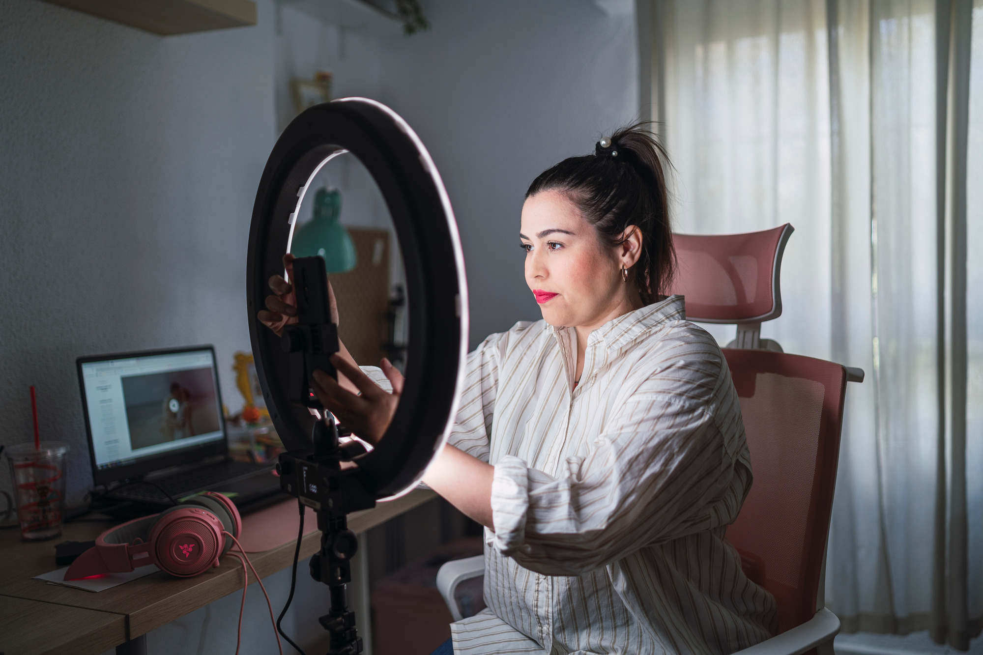 Photo of an influencer with a ring light setting up to record a video